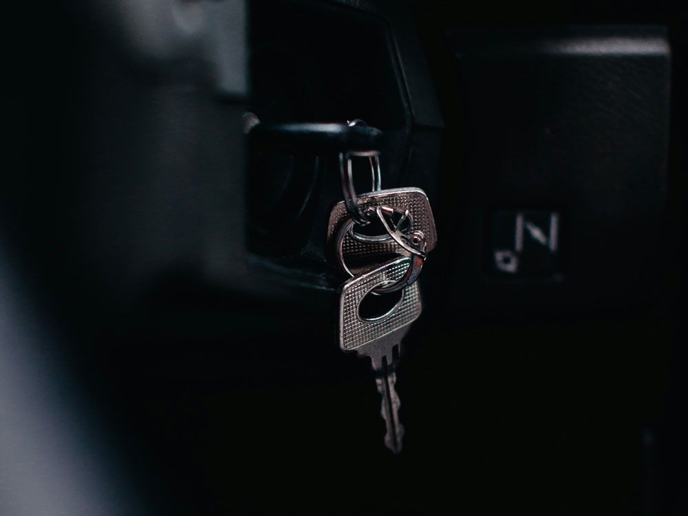 A ring of keys hanging from a vehicle's ignition